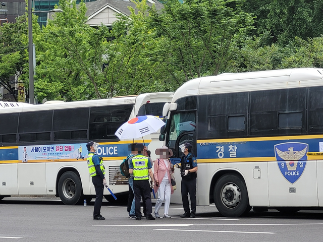 [서울=뉴시스]정유선기자=서울 종로구 동화면세점 앞을 지나는 한 시민이 경찰에게 항의하고있다. 2021. 8. 14 *재판매 및 DB 금지