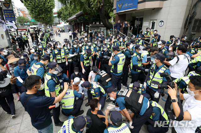 [서울=뉴시스] 조성우 기자 = 전광훈 사랑제일교회 목사가 대표로 있는 국민혁명당의 '1인 걷기 대회' 행사가 열린 14일 오전 서울 종로구 탑골공원 앞에서 경찰이 행사 참가자들에게 해산을 요구하고 있다. 2021.08.14. xconfind@newsis.com