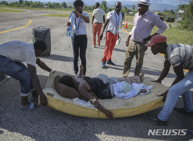 [레카이=AP/뉴시스] 14일(현지시간) 아이티에서 규모 7.2의 지진이 발생해 레카이의 한 주민이 다쳐 수도 포르토프랭스로 이송되기 위해 옮겨지고 있다. 진앙은 수도 포르토프랭스에서 125㎞ 떨어진 곳으로 지금까지 최소 227명이 숨지고 수백 명이 다쳤으며 실종자 규모는 파악조차 되지 않았다. 피해 상황이 집계되지 않은 데다 여진도 이어져 피해 규모는 더욱 커질 것으로 우려된다. 2021.08.15.