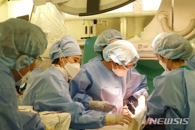 [서울=뉴시스]이미영 서울아산병원 산부인과 교수가 산후출혈로 인해 자궁동맥색전술을 받은 전치태반 산모에게 분만 후 처치를 시행하고 있다. (사진= 서울아산병원 제공) 2021.08.17