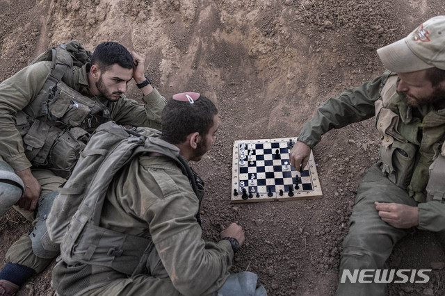 [가자지구=AP/뉴시스] 16일(현지시간) 이스라엘-가자 국경 인근에 배치된 이스라엘 군인들이 체스를 두면서 휴식하고 있다. 무장 정파 하마스가 통치하는 팔레스타인 가자지구에서 이스라엘을 향해 로켓포가 발사됐는데 이는 지난 5월에 치른 11일 전쟁 이후 3개월 만이다. 이스라엘군은 아이언 돔 미사일로 로켓포를 요격했다고 밝혔다. 2021.08.17.