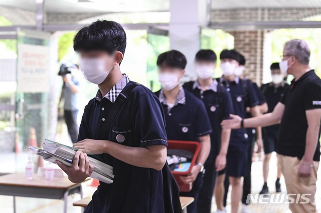 [서울=뉴시스] 사진공동취재단 = 일선 학교의 2학기 개학이 본격적으로 시작되는 지난 17일 서울 시내 한 고등학교에서 2~3학년 학생들이 등교하고 있다. 학생들은 교정에 들어서며 손소독과 체온 측정을 하고 각자의 교실로 들어갔다. 2021.08.17. photo@newsis.com