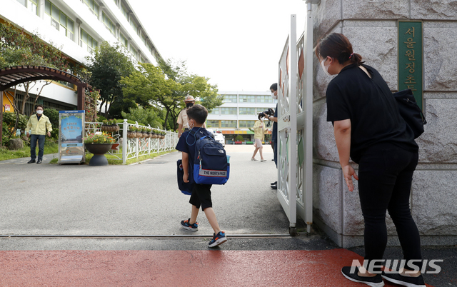 [서울=뉴시스] 사진공동취재단 = 한 초등학생이 부모님의 배웅을 받으며 등교하고 있다. 2021.08.17. photo@newsis.com 