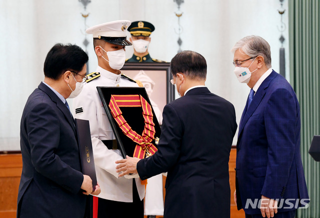 [서울=뉴시스] 전진환 기자 =  문재인 대통령이 17일 청와대에서 열린 고 홍범도 장군 훈장 추서식에서 홍범도장군기념사업회 우원식 이사장에게 건국훈장 대한민국장을 추서하고 의장병이 들고 있는 추서판에 부장을 걸어주고 있다. 2021.08.17. amin2@newsis.com