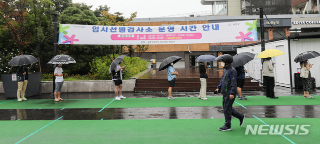 [서울=뉴시스] 권창회 기자 = 코로나19 신규 확진자가 1,805명으로 집계된 18일 오전 서울 서초구 고속버스터미널 임시선별검사소에서 시민들이 검사를 받기 위해 우산을 쓰고 대기하고 있다. 2021.08.18. kch0523@newsis.com