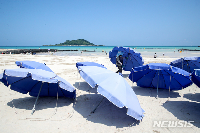 [제주=뉴시스] 우장호 기자 = 제주 지역 사회적 거리두기가 4단계로 격상된 18일 오전 제주시 한림읍 협재해수욕장에서 마을 관계자들이 파라솔을 정리하고 있다. 4단계 조치로 제주 도내 12개 지정 해수욕장은 오는 29일까지 모두 폐장한다. 2021.08.18. woo1223@newsis.com