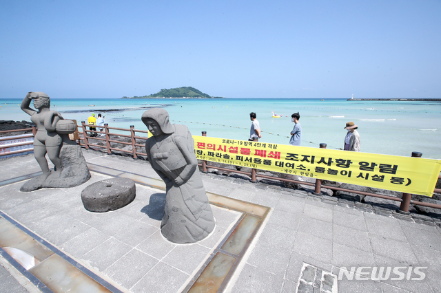 [제주=뉴시스] 우장호 기자 = 제주 지역 사회적 거리두기가 4단계로 격상된 18일 오전 제주시 한림읍 협재해수욕장에 해수욕장 폐장을 안내하는 현수막이 설치돼 있다. 4단계 조치로 제주 도내 12개 지정 해수욕장은 오는 29일까지 모두 폐장한다. 2021.08.18. woo1223@newsis.com