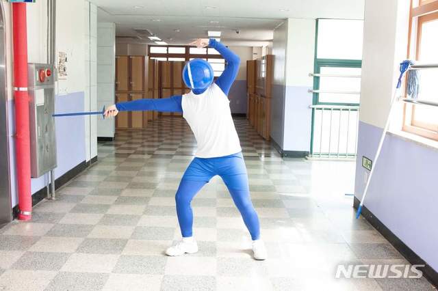 [의정부=뉴시스] 의정부고등학교 학생자치회가 공개한 졸업사진. 한 학생이 '2020도쿄올림픽' 개회식 때 화제가 된 '픽토그램 팬터마임'을 패러디 하고 있다. (사진=의정부고 학생자치회 제공)