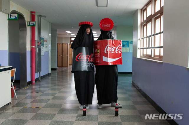 [의정부=뉴시스] 의정부고등학교 학생자치회가 공개한 졸업사진. 두명의 학생이 '코카콜라'로 분장하고 졸업사진에 촬영에 참여하고 있다. (사진=의정부고 학생자치회 제공)