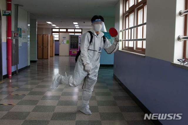 [의정부=뉴시스] 의정부고등학교 학생자치회가 공개한 졸업사진. 한 학생이 '2020도쿄올림픽' 국가대표 탁구선수 신유빈이 인천공항에서 방역복을 입었던 모습을 패러디 하고 있다. (사진=의정부고 학생자치회 제공)