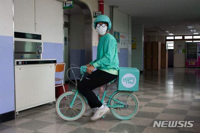 [의정부=뉴시스] 의정부고등학교 학생자치회가 공개한 졸업사진. 한 학생이 배달앱 서비스를 패러디 하고 있다. (사진=의정부고 학생자치회 제공)