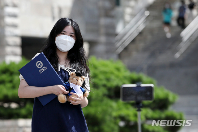 [서울=뉴시스] 조성우 기자 = 2020학년도 후기 학위수여식이 열린 지난해 8월19일 서울 성동구 한양대학교에서 한 졸업생이 사진을 찍고 있다. 한양대는 사회적 거리두기 4단계 지침에 따라 오프라인 학위수여식을 취소하고 온라인으로 진행했다. 포토존 설치와 학위복 대여도 금지했다. 2021.08.19. xconfind@newsis.com