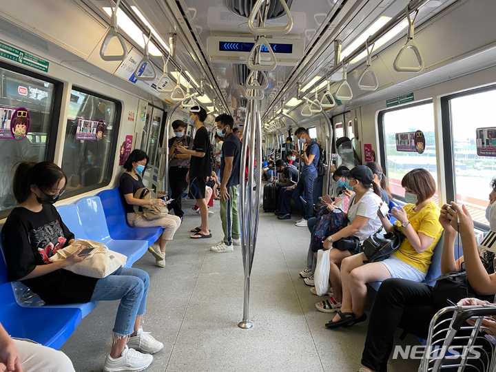 [싱가포르=AP/뉴시스] 지난 5월19일(현지시간) 싱가포르 지하철에서 승객들이 마스크를 쓰고 있다. 2021.09.25.