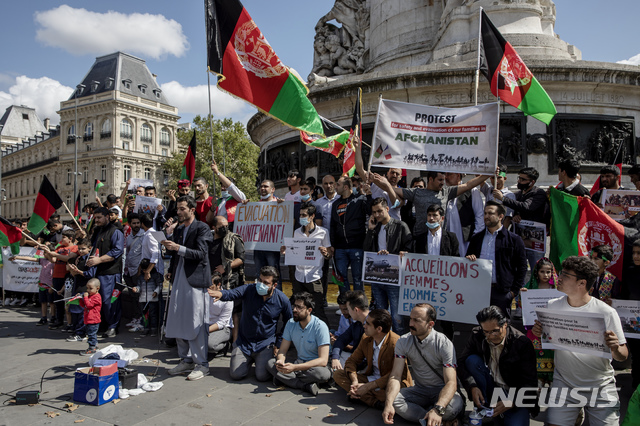 [파리=AP/뉴시스] 지난 8월22일(현지시간) 프랑스 파리의 한 광장에서 아프가니스탄 협회 회원들이 아프간에서 대피한 난민에 대한 연대를 촉구하고 있다. 2021.12.10.