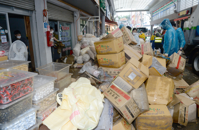 [울산=뉴시스] 배병수기자 = 24일 태풍 오마이스의 영향으로 수해가 발생한 울산 중구 태화시장 옛날과자 상가가 물에 잠겨 봉사자들이 물건을 폐기 처분하고 있다. 태화시장은 2016년 태풍 차바로 큰 피해가 발생한 곳 중 한 곳이다. 2021.08.24. bbs@newsis.com