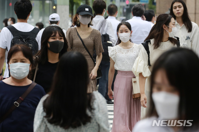 [도쿄=AP/뉴시스] 24일 일본 도쿄에서 코로나19 확산 방지를 위해 마스크를 쓴 시민들이  교차로를 건너고 있다. 일본 내 코로나19 확산이 지속하면서 일본 정부는 긴급사태 선언 지역을 확대할 것으로 보인다. 2021.08.24. 