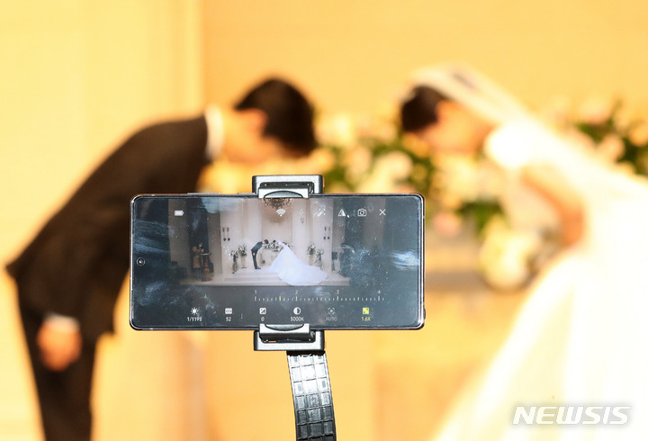 [서울=뉴시스] 백동현 기자 = 현행 거리두기 4단계 조치에 따라 49명으로 결혼식장 참석 인원이 제한되고 있는 28일 오후 서울시내 한 웨딩홀에서 결혼식이 모바일로 생중계되고 있다. 2021.08.28. livertrent@newsis.com *해당 사진은 이 기사와 관련이 없음