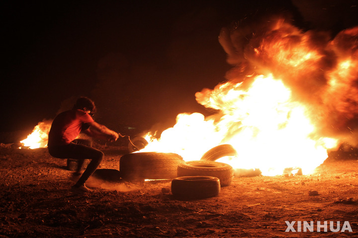 [ 가자지구=신화/뉴시스]자자지구 국경에서 이스라엘군과 싸우는 팔레스타인 시위대가 28일 밤(현지시가) 자동차 타이어에 불을 붙이며 항전을 다짐하고 있다.&nbsp; 이 지역에서의 야간 충돌은 거의 2년만에 재개된 것이라고 목격자들은 전했다.