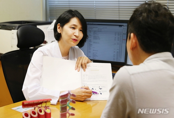 [서울=뉴시스] 김홍규 서울아산병원 건강의학과 교수가 건강검진 수검자에게 검진 결과를 설명하고 있다. (사진= 서울아산병원 제공) 2021.08.30