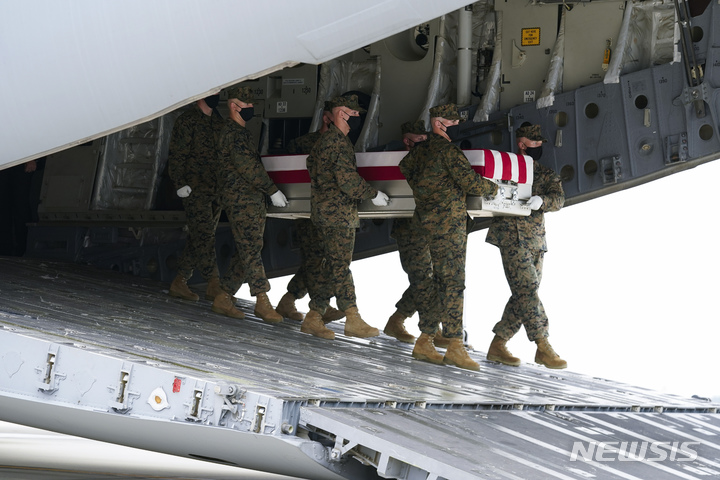 [도버공군기지=AP/뉴시스] 29일(현지시간) 미 델라웨어주 도버 공군기지에서 군인들이 아프가니스탄 카불 공항 자폭테러로 숨진 군인의 유해함을 옮기고 있다. 이날 카불공항 테러로 숨진 13명의 미군 유해가 고국에 돌아갔다. 2021.08.30 