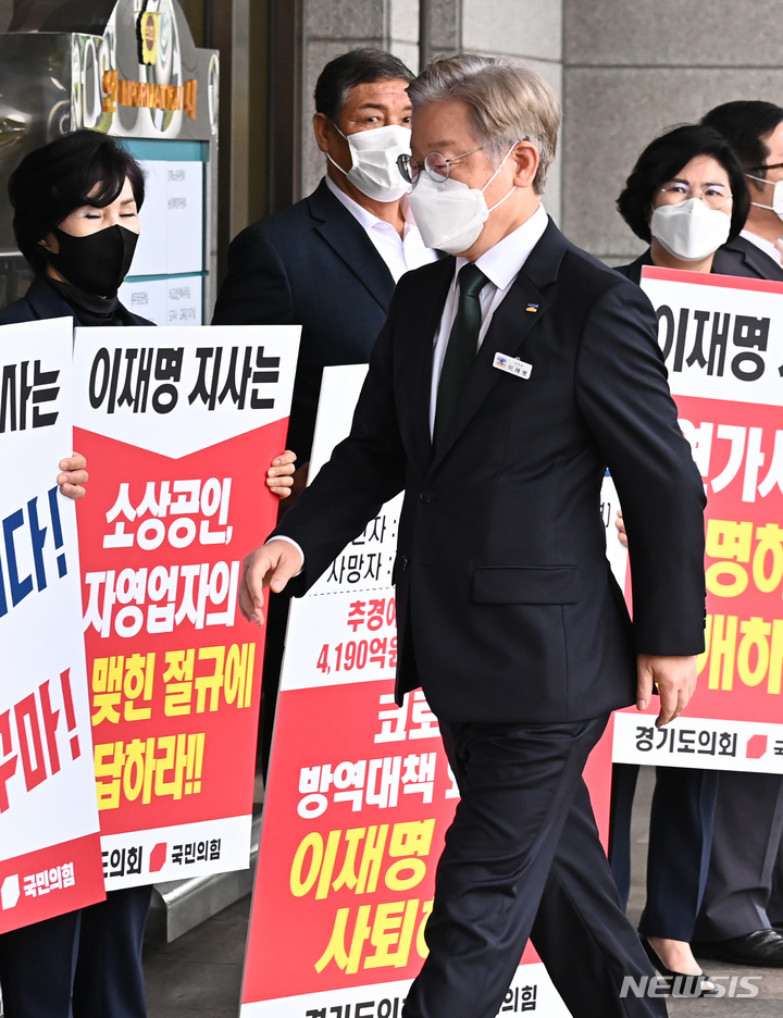 [수원=뉴시스] 김종택기자 = 이재명 경기도지사가 31일 오전 경기도 수원시 경기도의회에서 열린 제354회 임시회 제1차 본회의에 출석하기 위해 청사로 들어서자 경기도의회 국민의힘 소속 의원들이 이지사의 사퇴를 촉구하며 피켓 시위를 벌이고 있다. 2021.08.31. jtk@newsis.com