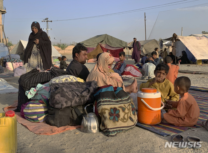 [차만(파키스탄)=AP/뉴시스] 31일(현지시간) 파키스탄 접경 지역 차만 외곽에서 아프가니스탄 난민들이 텐트 밖에 앉아 있다. 2021.09.01.
