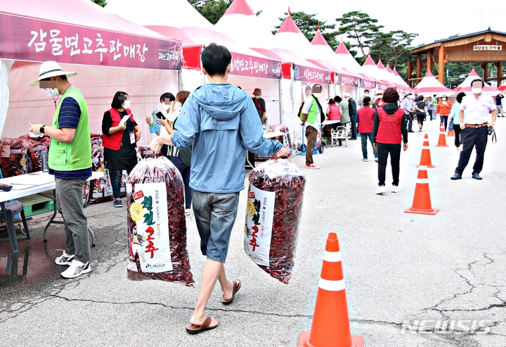 [괴산=뉴시스] 강신욱 기자 = 2021 괴산고추축제 순정농부 고추장터가 2일 충북 괴산군 괴산읍 동부리 괴산군농산물유통센터 광장에서 열린 가운데 한 소비자가 구매한 괴산청결고추를 운반하고 있다. 2021.09.02. ksw64@newsis.com