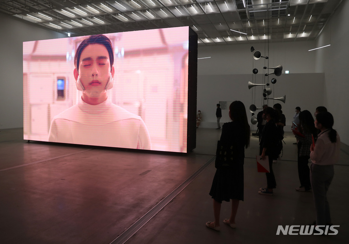 [서울=뉴시스] 고승민 기자 = 2일 서울 국립현대미술관에서 열린 'MMCA 현대차 시리즈 2021 : 문경원&전준호-미지에서 온 소식 : 자유의 마을'에서 취재진이 간담회 후 영상작품을 살펴보고 있다. 이번 전시에서는 남한 유일의 비무장지대(DMZ)에 위치한 경기 파주시 대성동 '자유의 마을'을 배경으로 촬영한 약 15분 분량의 영상 작품과 대형 회화·설치·아카이브·사진 등의 작품이 공개된다. 2021.09.02. kkssmm99@newsis.com