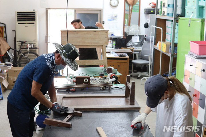 성남시 대형폐기물 처리장에서 폐가구 목재로 의자를 만들고 있다. ‘다시 프로젝트’의 하나.