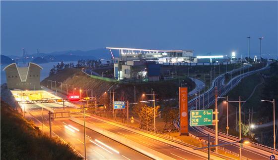 [부산=뉴시스] 부산 거가대로 오션블루 가덕휴게소 전경과 좌측에 가덕해저터널 입구와 멀리 다리의 주탑 전경. (사진= ‘오션블루 가덕휴게소 제공) *재판매 및 DB 금지