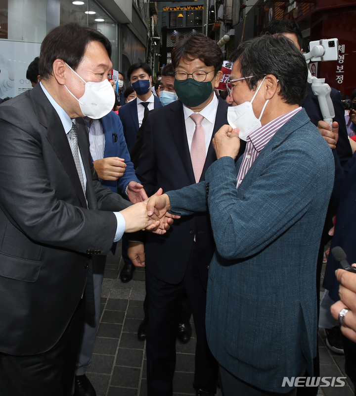 [춘천=뉴시스] 김경목 기자 = 9일 오후 윤석열 국민의힘 대선 경선 후보가 강원도 춘천시 명동 거리에서 만난 김홍규 전 강릉시의회 의장과 인사하고 있다. 권성동 의원이 가운데 서 있다. 윤 후보와 김 전 의장, 권 의원은 강릉에서 학생시절부터 만난 친구 관계이다. 2021.09.09. photo31@newsis.com