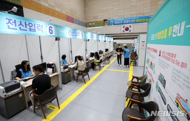 [서울=뉴시스] 고범준 기자 = 9일 오후 서울 마포구 마포아트센터에 마련된 코로나19 예방접종센터에서 시민들이 접종을 받고 전산입력을 하고 있다. 정부는 올해 추석 전 전 국민 1차 접종률 70%, 10월 말까지 접종 완료율 70% 달성을 목표로 하고 있고 현재의 접종추세를 감안해 오는 11월부터 '단계적 일상회복'을 검토하고 있다. 한편 이날 코로나19 신규 확진자는 2,049명으로 집계됐다. 2021.09.09. bjko@newsis.com