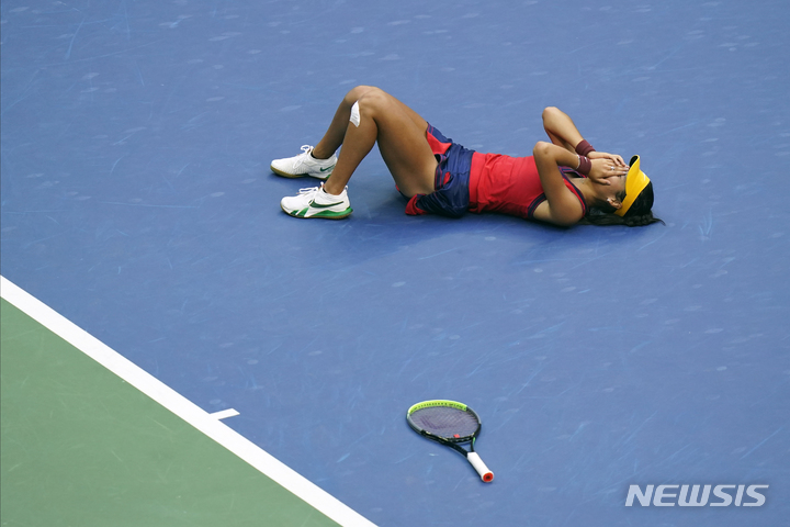 [뉴욕=AP/뉴시스]여자 테니스에 10대 돌풍을 일으킨 영국의 엠마 라두카누(18)와 캐나다의 레일라 페르난데스(19)가 결승에서 맞붙어 화제를 모은 유에스 여자오픈 테니스에서 세트 스코어 2-0으로 승리한 라두카누가 코트에 누워 감격하고 있다. 세계 랭킹 5위 안에 든 선수 3명을 꺾으며 파란을 일으켰던 페르난데스는 체력이 소진돼 힘을 발휘하지 못했다. 2021.9.12