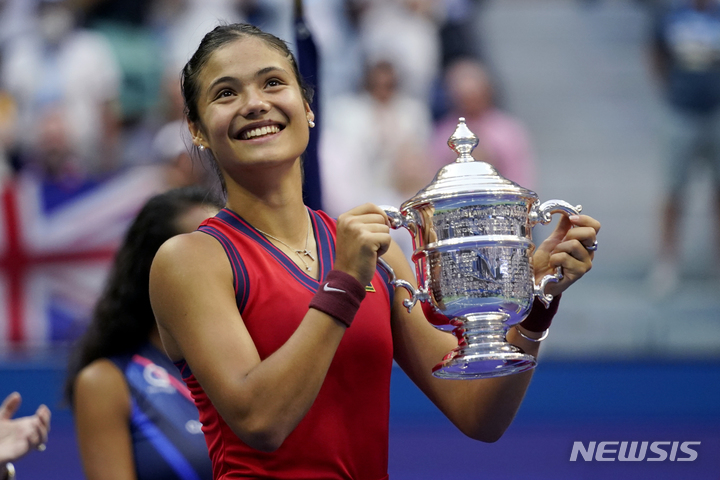[뉴욕=AP/뉴시스] 엠마 라두카누(150위·영국)가 11일(현지시간) 미국 뉴욕의 아서애시스타디움에서 열린 US오픈 테니스 대회 여자 단식 결승전에서 레일라 페르난데스(73위·캐나다)를 물리치고 우승, 트로피를 들고 활짝 웃고 있다. 10대 선수끼리 맞붙은 결승전에서 라두카누는 페르난데스를 세트스코어 2-0(6-4 6-3)으로 꺾고 10경기 무실세트 우승을 차지했다. 2021.09.12.
