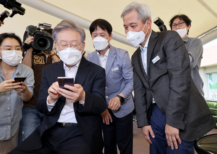 [오산=뉴시스] 경기사진공동취재단 = 이재명 경기지사가 13일 오후 오산 오색시장에서 추석맞이 전통시장 현장을 방문해 '장보고 배달특급' 앱을 이용해 제수용품을 구입하고 있다.오른쪽은 곽상욱 오산시장. 2021.09.13. photo@newsis.com