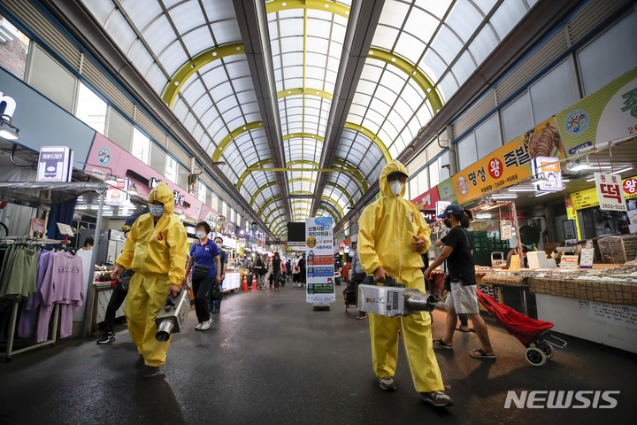 [서울=뉴시스] 정병혁 기자 = 13일 오후 서울 양천구 신영시장에서 시장상인회 관계자들이 코로나19 확산 방지를 위한 방역작업을 하고 있다. 2021.09.13. jhope@newsis.com