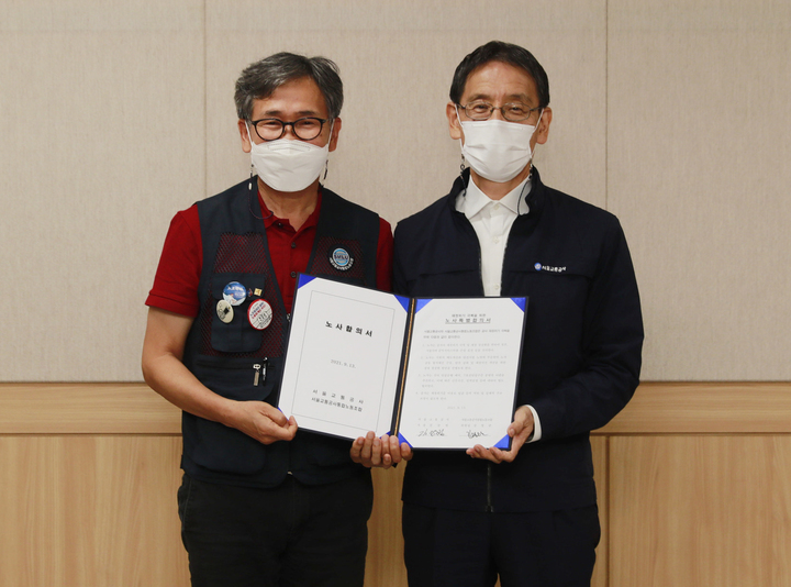 [서울=뉴시스] 김상범 서울교통공사 사장과 김철관 서울교통공사 노동조합 위원장이 13일 서울 성동구 서울교통공사에서 노사합의서를 체결한 뒤 기념촬영 하고 있다. (사진=서울교통공사 제공) 2021.09.14. photo@newsis.com *재판매 및 DB 금지