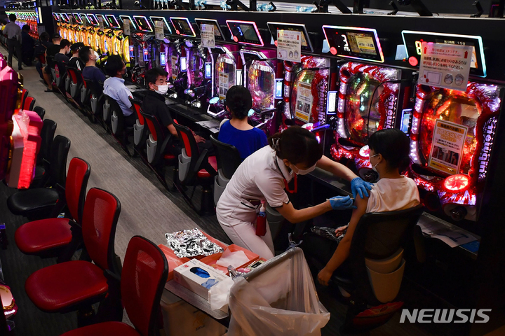 [오사카=AP/뉴시스] 13일 일본 오사카의 파친코 매장 '프리덤'에서 한 여성이 모더나 백신 1차 접종을 하고 있다. 인근 병원에서는 코로나19 백신 접종소가 된 이 파친코 매장에 의료진을 파견해 이틀 동안 직원, 단골손님 등 1500여 명에게 백신을 투여한다. 2021.09.14