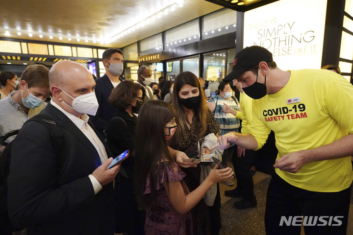 [뉴욕=AP/뉴시스] 14일(현지시간) 미국 뉴욕의 민스코프 극장에서 브로드웨이의 '라이언 킹' 공연이 재개돼 입장객들이 백신 접종 증명서를 방역 요원에게 보여주고 있다. 이 공연에는 백신 접종 증명서가 있어야 입장할 수 있다. 2021.09.15.