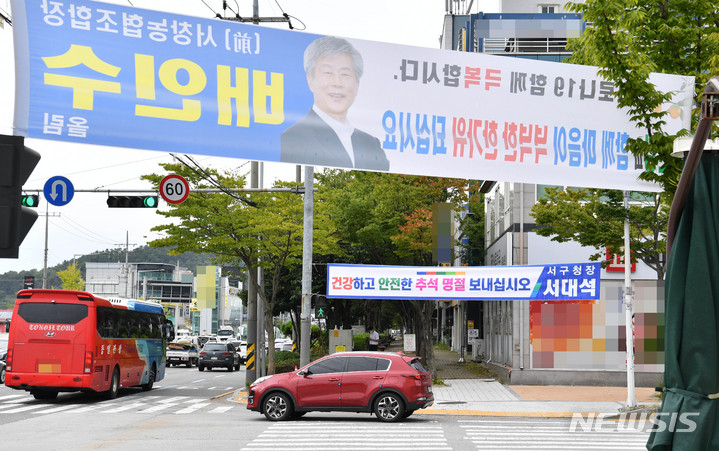 [광주=뉴시스] 변재훈 기자 = 16일 오후 광주 서구 치평동 한 교차로에 현직 구청장을 비롯한 입후보 예정자들이 내건 추석 귀성객 맞이 불법 현수막이 방치돼 있다. 지정 게시대가 아닌 곳에 현수막을 내걸 경우 옥외광고물 등 관리법에 따라 과태료 부과대상이다. 2021.09.16. wisdom21@newsis.com