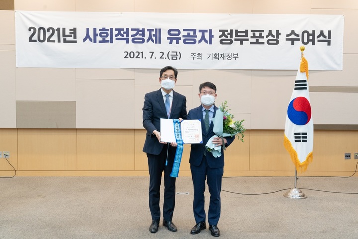 7월2일 광주 김대중컨벤션센터에서 진행된 '2021년 사회적경제 유공자 정부포상 수여식'에서 사회적가치부문 국무총리표창을 수상한 한국예탁결제원의 금종익 정보보호최고책임자(오른쪽)가 한훈 기획재정부 차관보와 기념촬영을 하고 있다. (사진=한국예탁결제원) *재판매 및 DB 금지