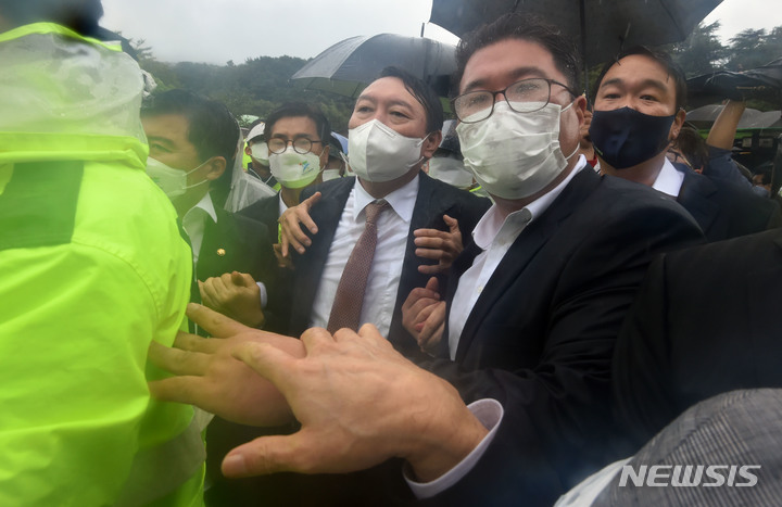 [구미=뉴시스] 이무열 기자 = 윤석열 국민의힘 대선 경선 후보가 17일 오전 경북 구미시 상모동 박정희 전 대통령 생가를 찾아 분향을 마친 뒤 박근혜 전 대통령 구속에 항의하는 보수단체 회원들이 대거 몰리자, 경찰의 호위를 받으며 생가를 나오고 있다. 2021.09.17. lmy@newsis.com