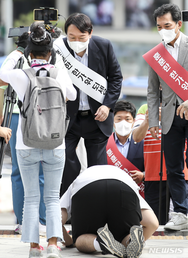 [서울=뉴시스] 정병혁 기자 = 윤석열 국민의힘 대선 경선 예비후보가 19일 오전 서울 중구 서울역에서 한 시민에게 절을 받고 있다. 2021.09.19. jhope@newsis.com