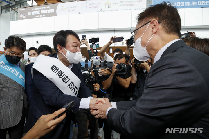 [서울=뉴시스] 정병혁 기자 = 윤석열 국민의힘 대선 경선 예비후보와 최재형 후보가 19일 오전 서울 중구 서울역 대합실에서 인사를 나누고 있다. 2021.09.19. jhope@newsis.com