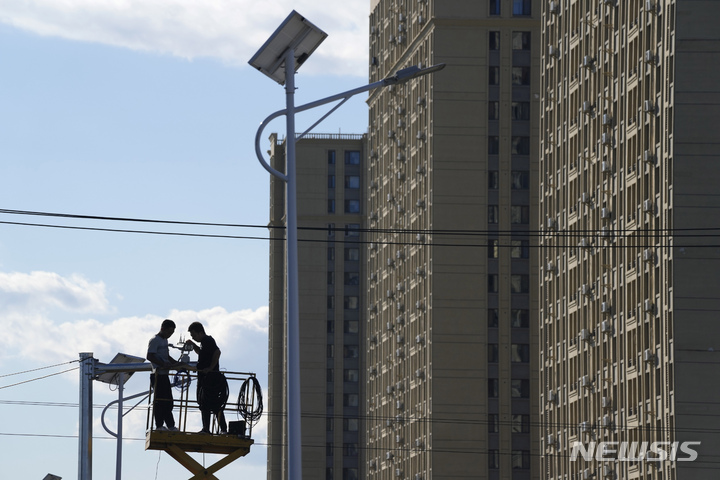 [베이징=AP/뉴시스] 인부들이 헝다 그룹의 주거 단지 인근에 교통 감시 카메라를 설치하고 있다. 2021.09.21.