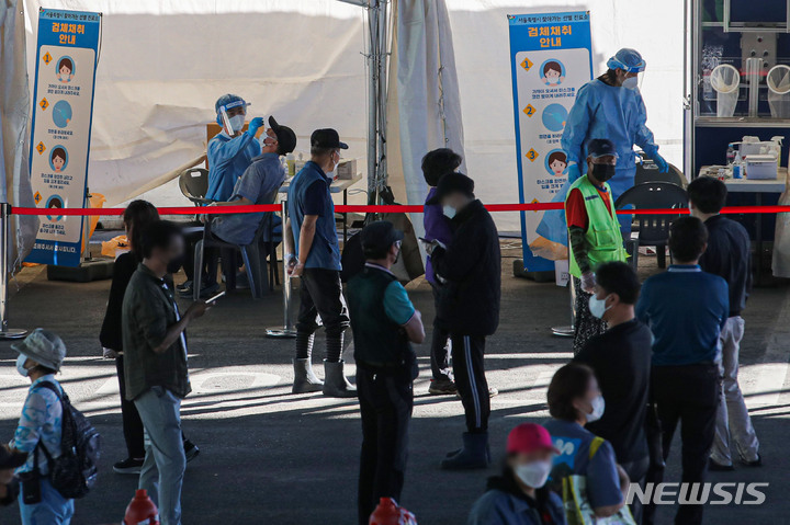 [서울=뉴시스] 권창회 기자 = 가락시장 관련 집단감염 확산세가 지속되고 있는 23일 오전 서울 송파구 가락시장에 마련된 찾아가는 선별진료소에서 시장 종사자들이 검사를 받기 위해 대기하고 있다. 2021.09.23. kch0523@newsis.com