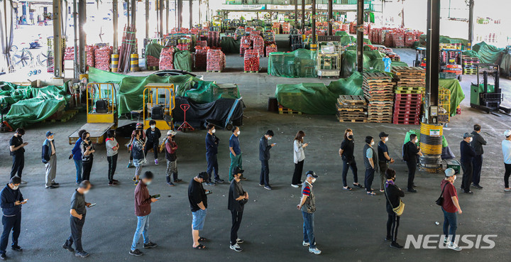 [서울=뉴시스] 권창회 기자 = 가락시장 관련 집단감염 확산세가 지속되고 있는 23일 오전 서울 송파구 가락시장에 마련된 찾아가는 선별진료소에서 시장 종사자들이 검사를 받기 위해 대기하고 있다. 2021.09.23. kch0523@newsis.com