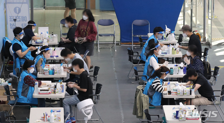 [서울=뉴시스] 권창회 기자 = 코로나19 백신 1차 접종률이 71.2%를 기록중인 23일 오전 서울 송파구 체육문화센터에 마련된 예방접종센터에서 시민들이 예진표를 작성하고 있다. 2021.09.23. kch0523@newsis.com