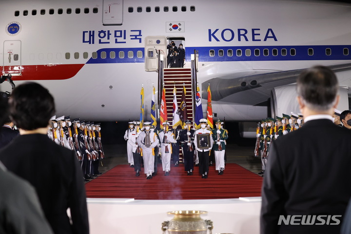 [성남=뉴시스] 김진아 기자 = 방미 일정을 마치고 귀국한 문재인 대통령과 김정숙 여사가 23일 밤 서울공항에서 열린 국군 전사자 유해 봉환식에서 의장병이 국군 전사자 유해를 운구하는 모습을 지켜보고 있다. 2021.09.23. bluesoda@newsis.com