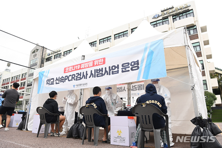 [서울=뉴시스] 사진공동취재단 = 28일 오전 서울 종로구 동성고등학교에서 학생들이 등교하며 코로나19 '신속 자가분자진단 유전자증폭(신속 PCR)' 검사를 받고 있다. 서울시교육청은 '교육시설 이동검체팀'을 1개팀에서 4개 팀 이상으로 확대하고, 기숙사 운영 학교 5개교를 대상으로 신속 PCR 검사를 시범 운영하는 등 다음 달 6일까지 '다중적 방역 집중 기간'으로 지정했다. 2021.09.28. photo@newsis.com